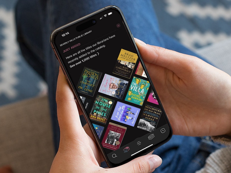 Someone looking at the Libby app on their phone, choosing a book to read from the newly added section on their local library's page