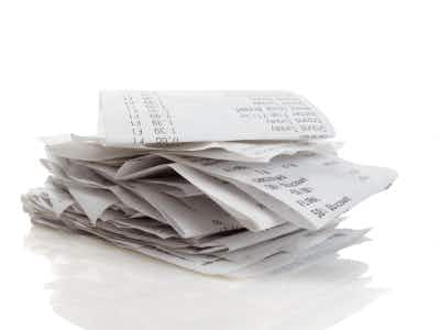 Stack of receipts piled high on white background