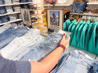 a woman looking a jeans in american eagle store