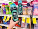 person holding a bottle of downy unstoppables by the shelf