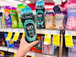 person holding a bottle of downy unstoppables by the shelf