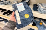 hand holding a pair of denim shorts at target