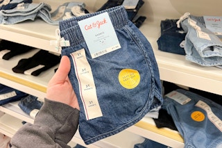 hand holding a pair of denim shorts at target