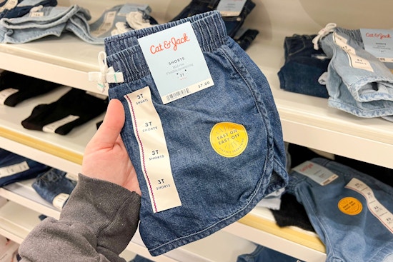 hand holding a pair of denim shorts at target