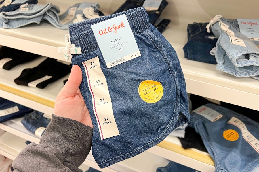 hand holding a pair of denim shorts at target