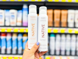 hand holding two bottle of Native whole body deodorant spray