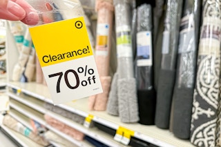 Target In-Store Clearance Sign (70%) held in front of area rugs