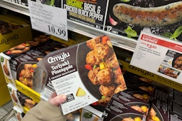 hand holding a box of amylu teriyaki pineapple chicken meatballs