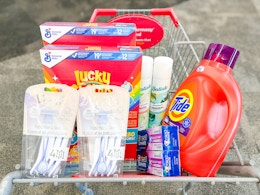 lucky charms cereal, batiste dry shampoo, tide detergent, venus razors, and crest toothpaste in a cart