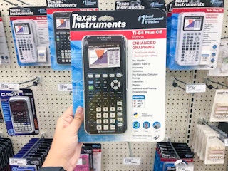 a hand holding a calculator in a package in front of a store display
