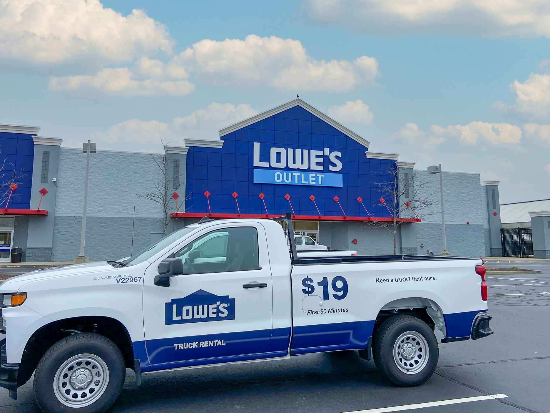 A Lowes Outlet store front with a rental truck parked in the parking lot