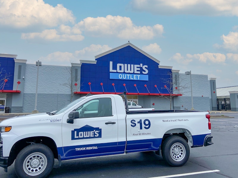 A Lowes Outlet store front with a rental truck parked in the parking lot