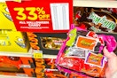 kroger halloween candy sale sign and a person's hand holding up a bag of candy 