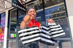 someone holding a bunch of Sephora shopping bags outside of the store