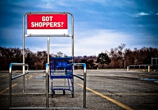 shopping cart sits in an empty lot