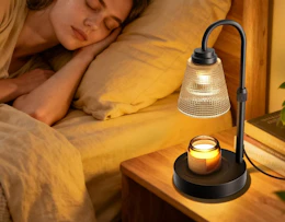 a candle warmer lamp on a nightstand next to a bed