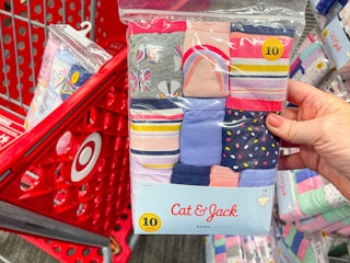 hanf holding out Cat & Jack underwear pack to the side of a Target shopping cart