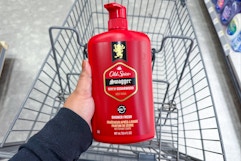 hand holding old spice body wash above a shopping cart