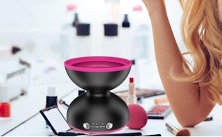 a black and pink makeup brush cleaner on a table with makeup