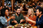 A group of people enjoy drinks and food at Applebees