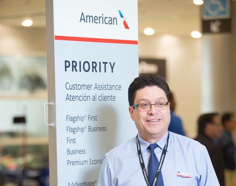 man standing next to american airline sign