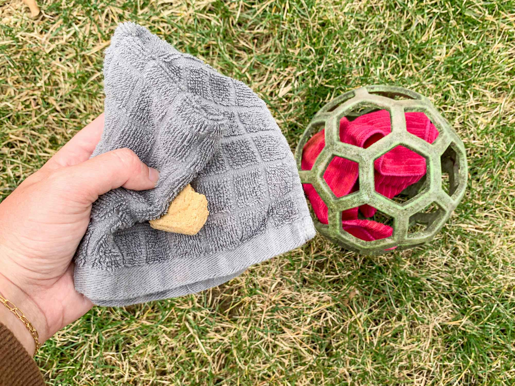 a person stuffing a ball with old wash cloths and treats