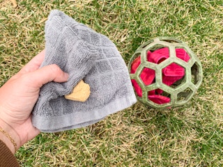 a person stuffing a ball with old wash cloths and treats