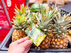 hand grabbing a del monte fresh pineapple off a target shelf