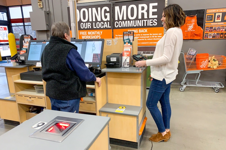 A woman and employee at the checkout register.