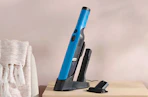 a teal handheld Shark vacuum