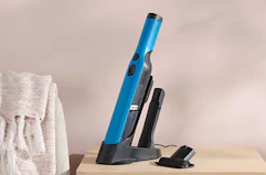 a teal handheld Shark vacuum