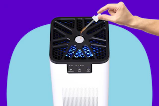 Stock photo of person adding essential oils to air purifier (close up shot)