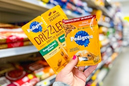 hand holding pedigree wet dog food pouches