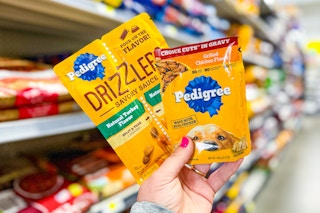 hand holding pedigree wet dog food pouches