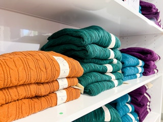 women's knit sweaters folded on a shelf