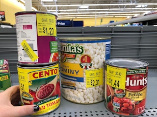 person looking at dented canned goods in walmart clearance aisle