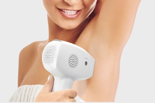 a woman using the Conair Lumilisse IPL Hair Removal Device
