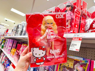 hand holding a bratz x hello kitty fashion doll in front of a target shelf