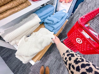 sweaters on shelf and being put in cart