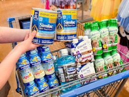 hand holding similac with pediasure pedialyte ensure and glucerna in walmart cart
