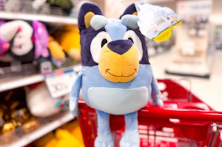 A Bluey Pillow Buddy sitting on top of a Target shopping cart