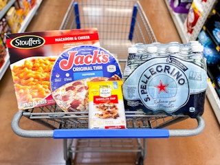 shopping cart with a frozen pizza, package of bottled water, and frozen cookie dough