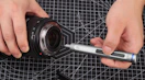 a hand using a screwdriver on a camera 