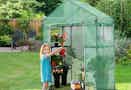 girl standing beside greenhouse