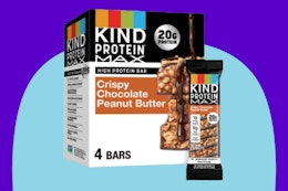 KIND Protein MAX Crispy Chocolate Peanut Butter Snack Bars on a blue background.