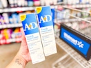 hand holding two containers of A+D Diaper rash ointment