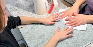A young girl getting a manicure at a nail salon