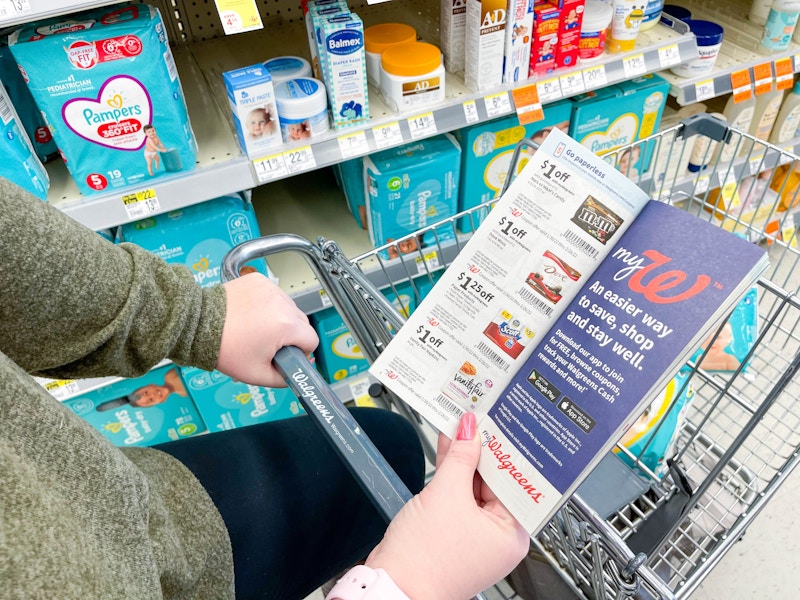 A person in Walgreens looking at walgreens coupon booklet