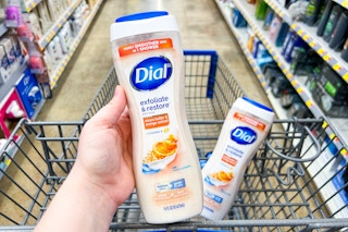hand holding a bottle of Dial body wash in front of another bottle sitting in the Walmart cart