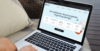 Someone using a laptop to. look at the Mark Cuban Cost Plus drugs website